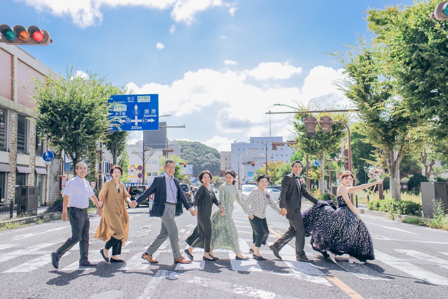 手を繋いで横断歩道を渡る8人家族