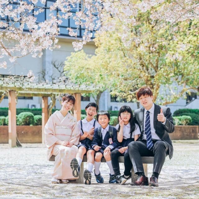 マツダロードスターとベージュのパンツ白いシャツでコーディネートした家族の