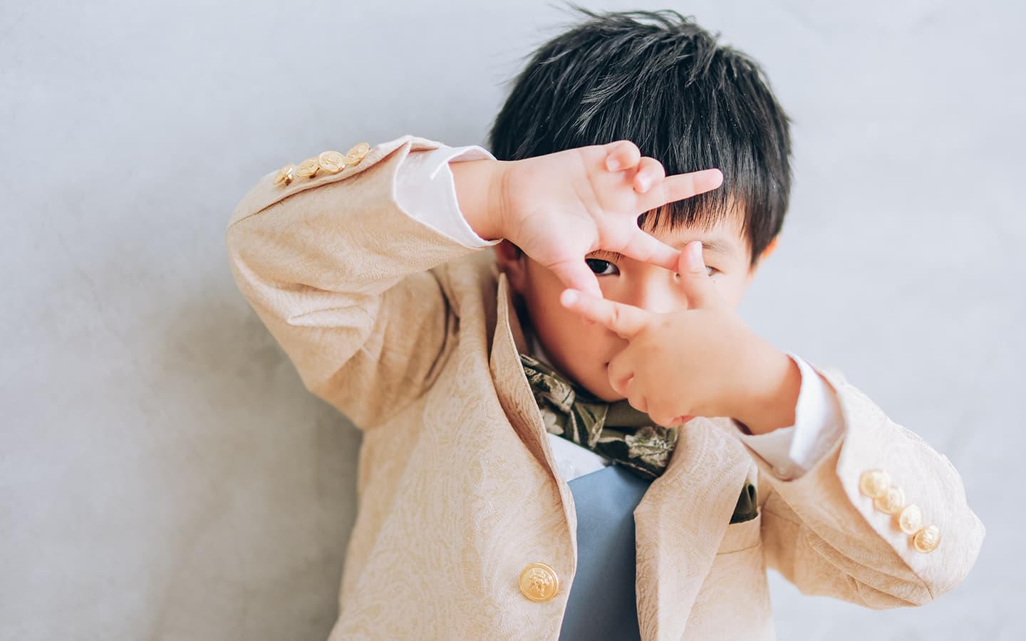 七五三白のタキシードを着てポーズをとる男の子